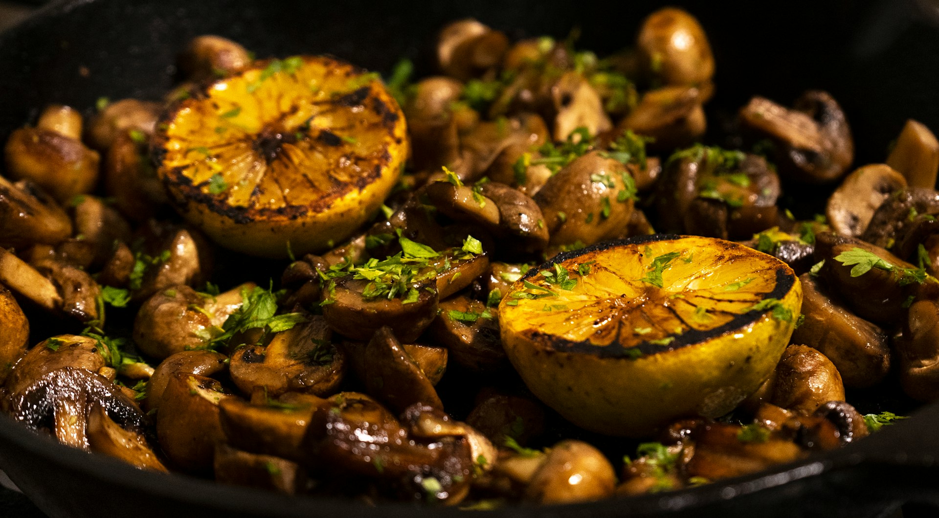 A pan filled with mushrooms and oranges on top of a stove